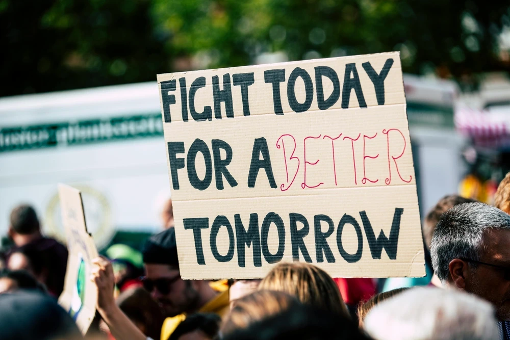 A cardboard sign at a climate protest with the message 'Fight Today for a Better Tomorrow'.
